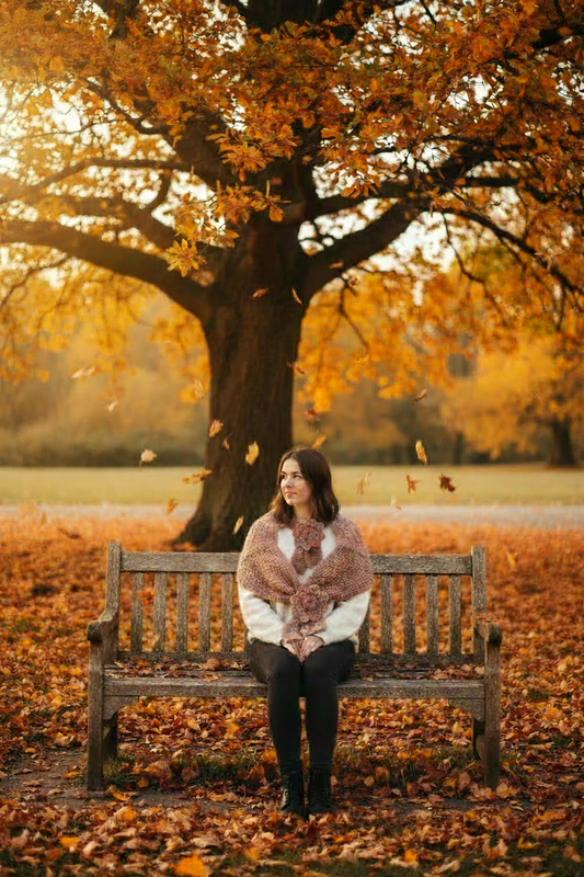 Woman on park bench with tiny neck wrap in autumn