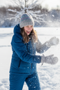 Young woman in snowball fight wearing colorwork hat